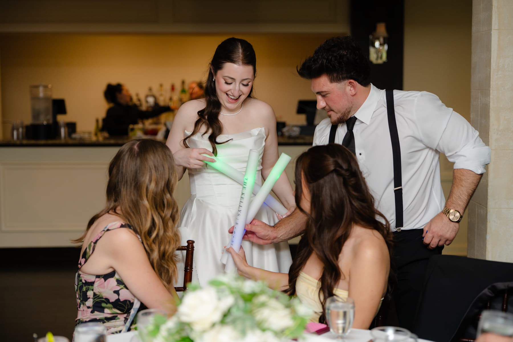 A bride and groom laughing with guests on the dance floor